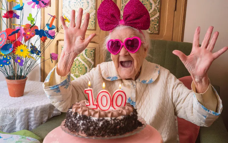 Happy 100th birthday celebration with senior woman and cake
