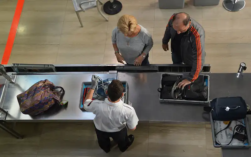 Airport staff checking baggage for liquids in spanish airport