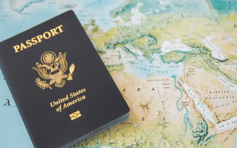 United States passport on a world map highlighting travel to Europe and Africa