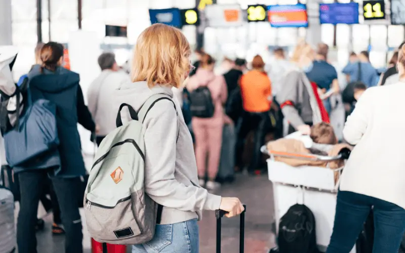 Passengers queuing at an airport waiting to check in.