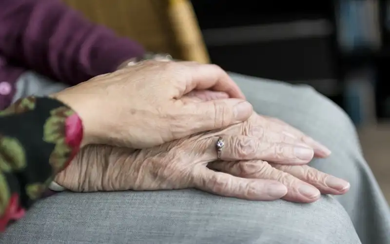 daughters hand on mothers hand for reassurance