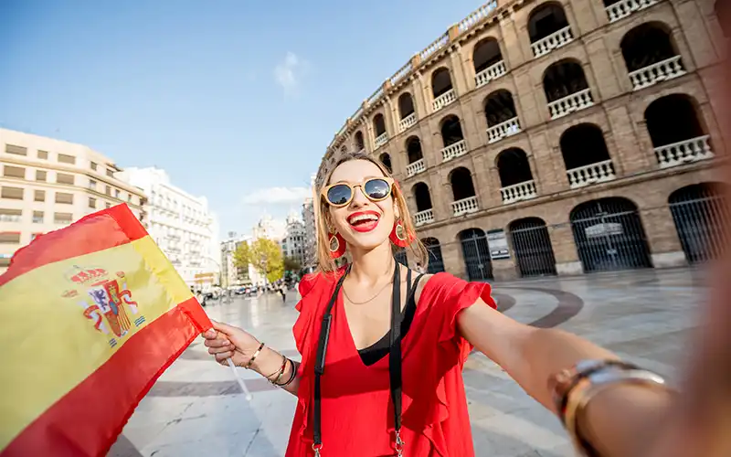 American woman holding Spanish flag
