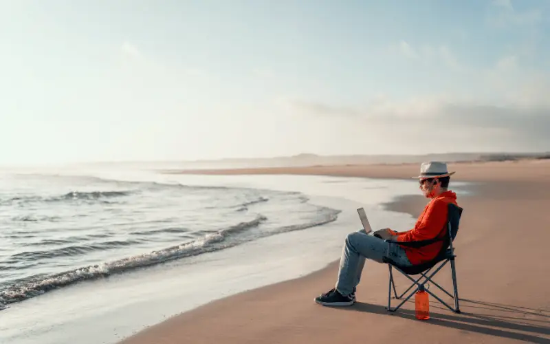 Remote worker using laptop on a quiet beach in Spain