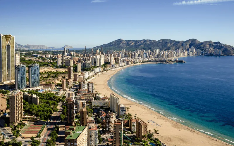 Aerial view of Benidorm beach with skyscrapers and clear blue sea on a sunny day