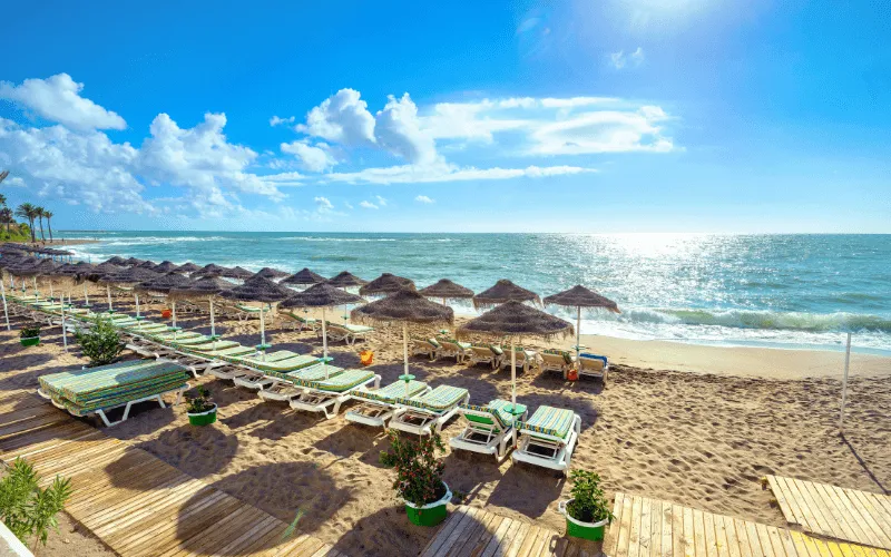 Blue flag beach in Spain with sun loungers and umbrellas on a sunny day