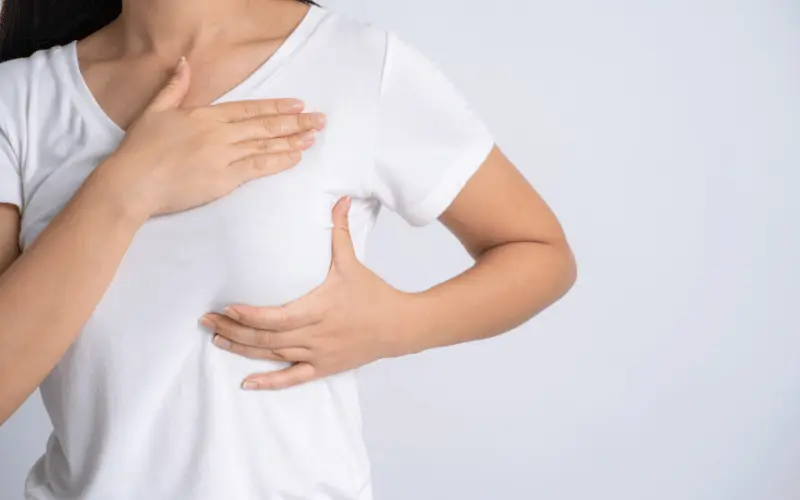 Woman performing breast self-exam for early detection of breast cancer