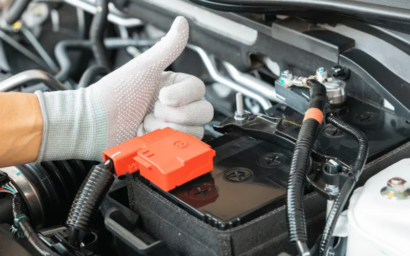mechanic giving thumbs up next to newly installed car battery in Spain