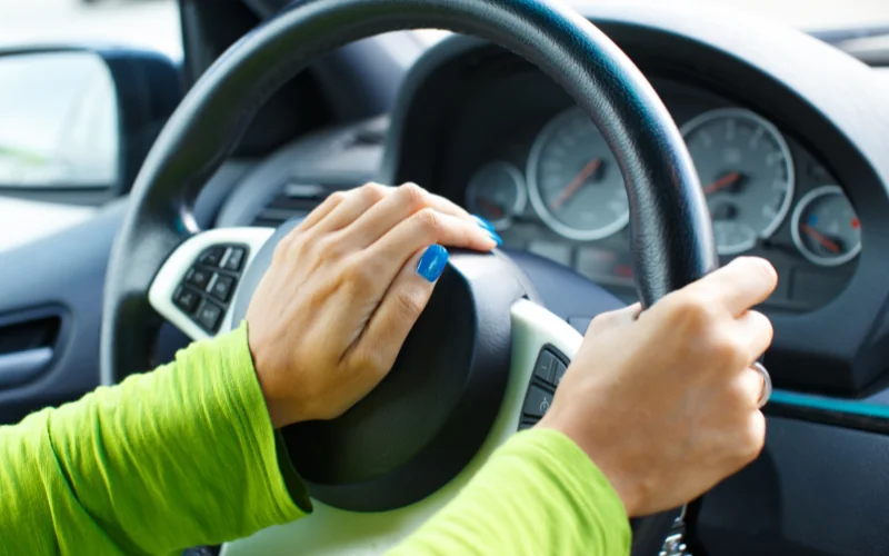 Person pressing car horn while driving