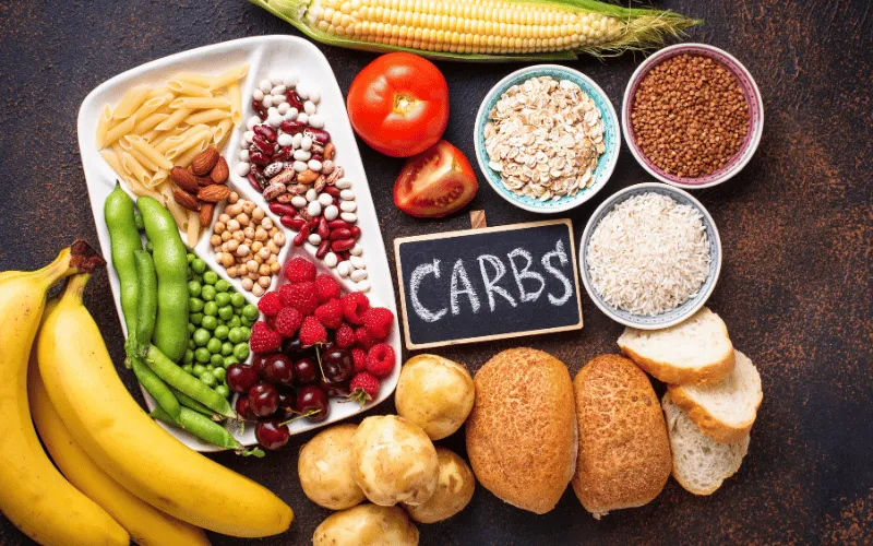 Assortment of healthy carbohydrate-rich foods including fruits, grains, and bread