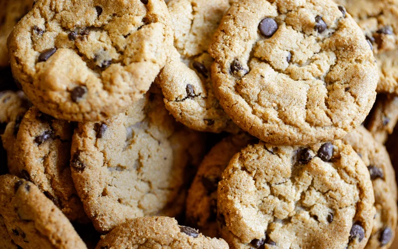 Freshly baked chocolate chip cookies stacked in a pile