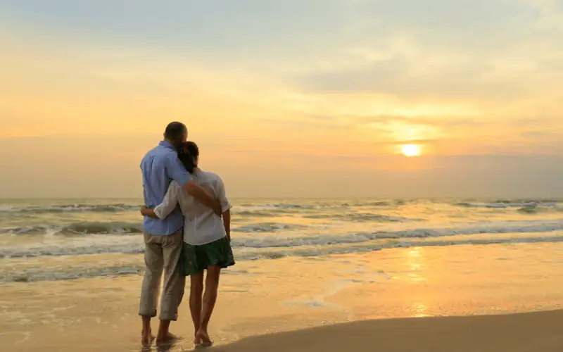 Couple watching sunset on the beach during a romantic evening