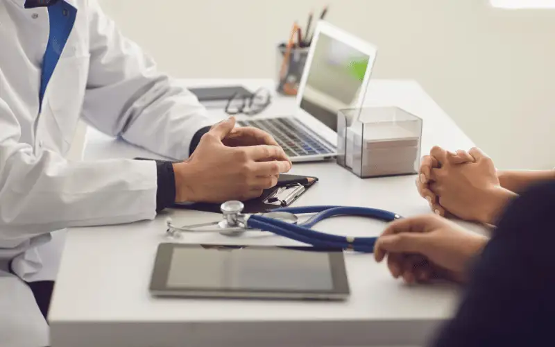 Doctor consulting patient during medical appointment in clinic office