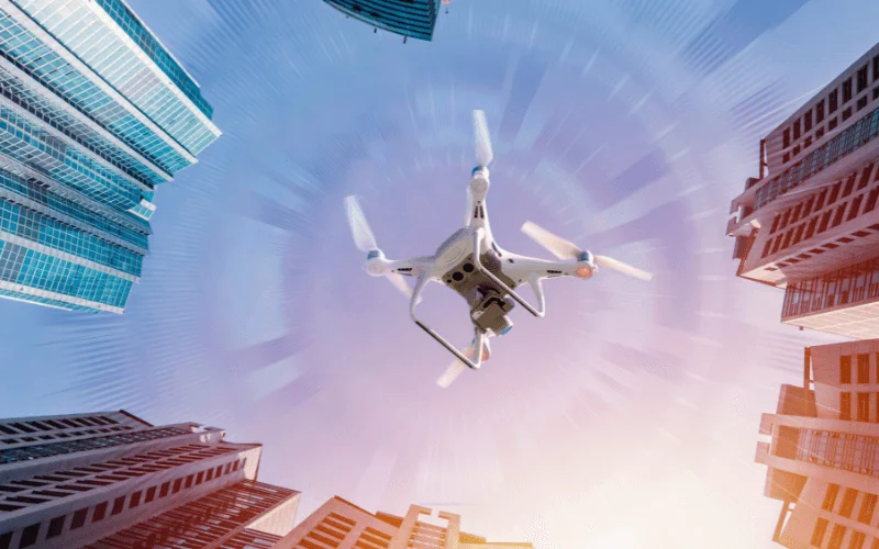Passenger drone flying between skyscrapers in a modern city