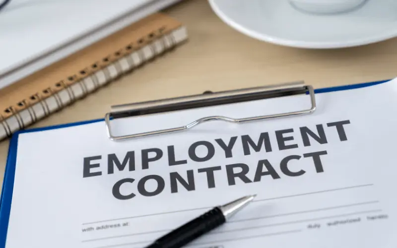 Clipboard with a black pen with large words of Employment Contract
