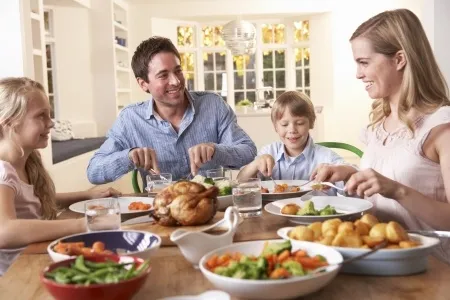 Family enjoying early dinner together at home with healthy food on the table