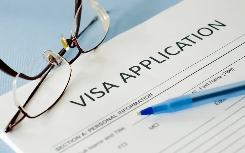 Visa application form with glasses and pen ready to be filled out
