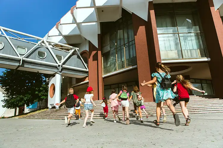 Expat kids running into school in Spain