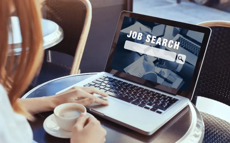 Person using laptop to search for jobs online at a cafeteria