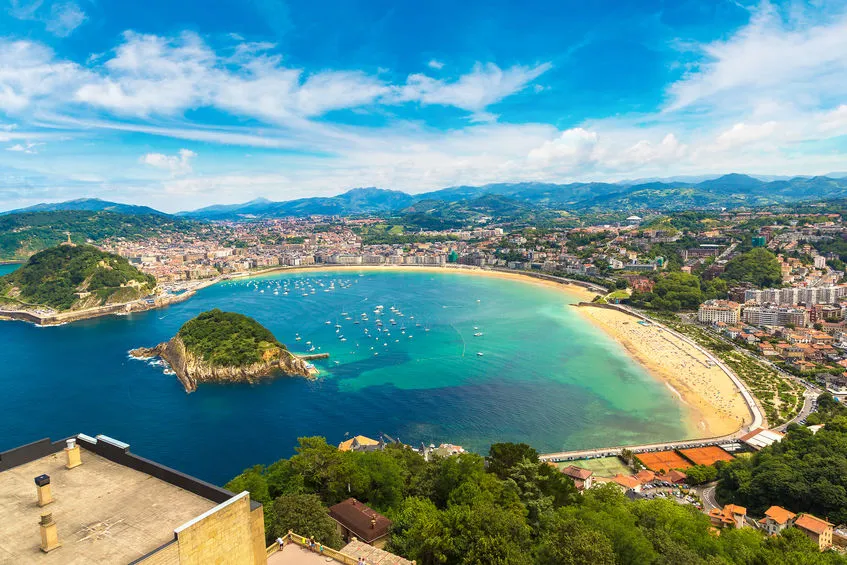 Scenic aerial view of La Concha Beach in San Sebastián, Spain, with turquoise waters and cityscape