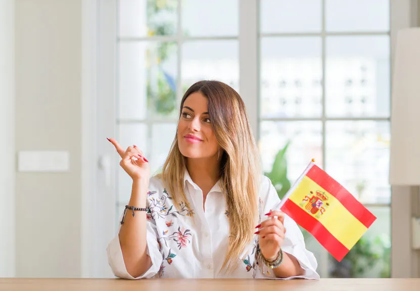 Woman holding Spanish flag indoors showing national pride
