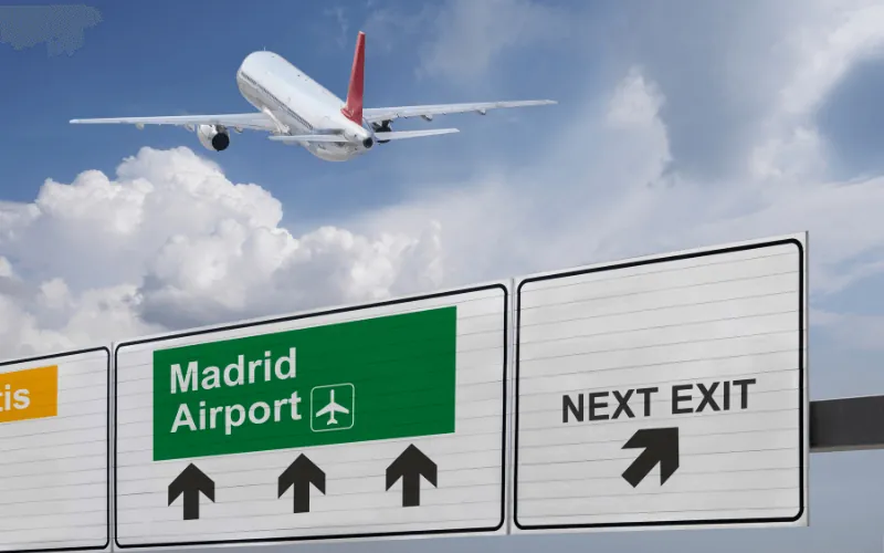 Airplane taking off near Madrid Airport sign on a cloudy day