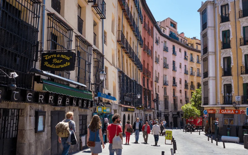 Tourists walking along a colorful historic street in Madrid city center