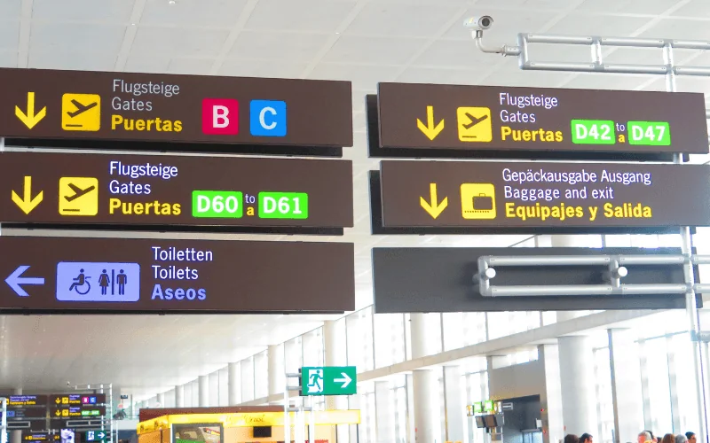 Airport directional signs for gates and baggage claim in Malaga Spain