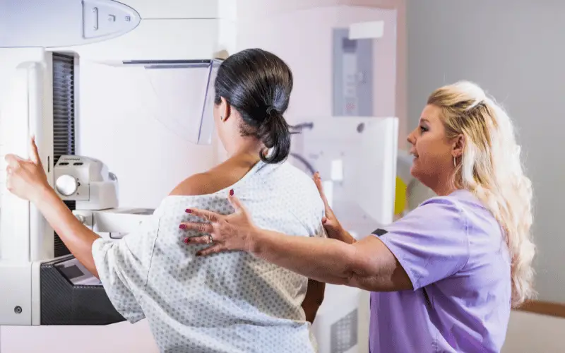 Healthcare worker assisting woman during a mammogram screening for breast cancer detection