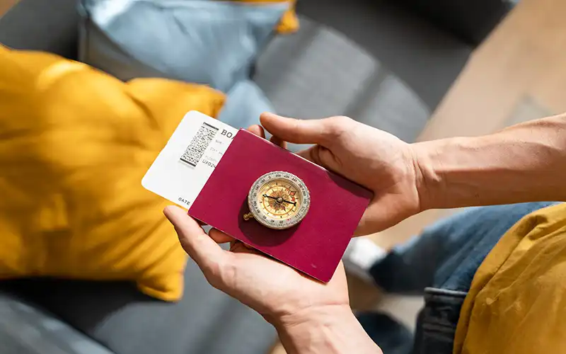 man holding passport with compass