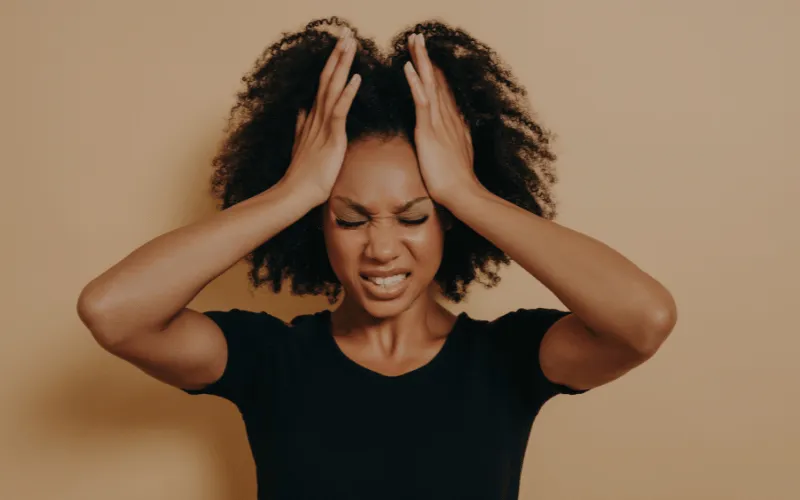 Young woman holding head in pain suffering from migraine