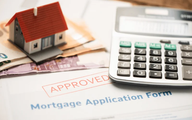Approved mortgage application form with house model, euro banknotes and calculator