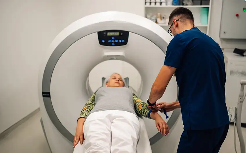 Patient lying on the scanner table while a radiographer prepares the scan