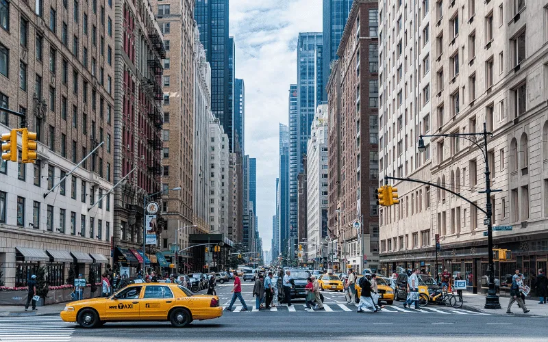 Busy New York City street with yellow taxis and pedestrians crossing