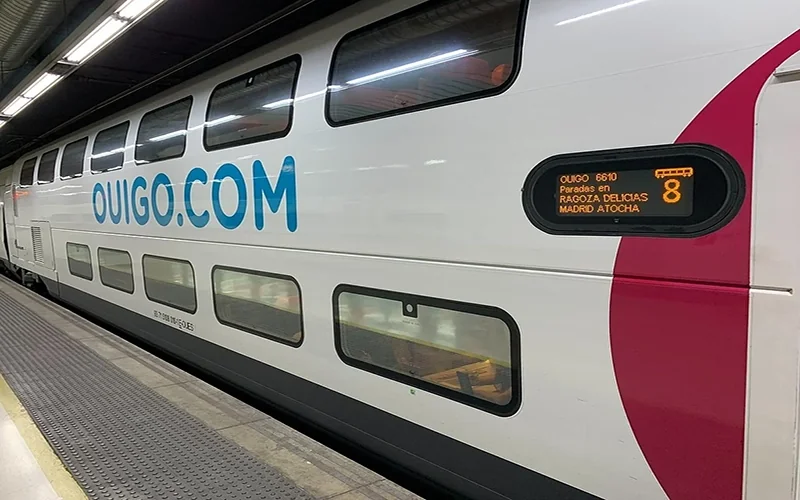 Ouigo high-speed train at station platform with digital destination display