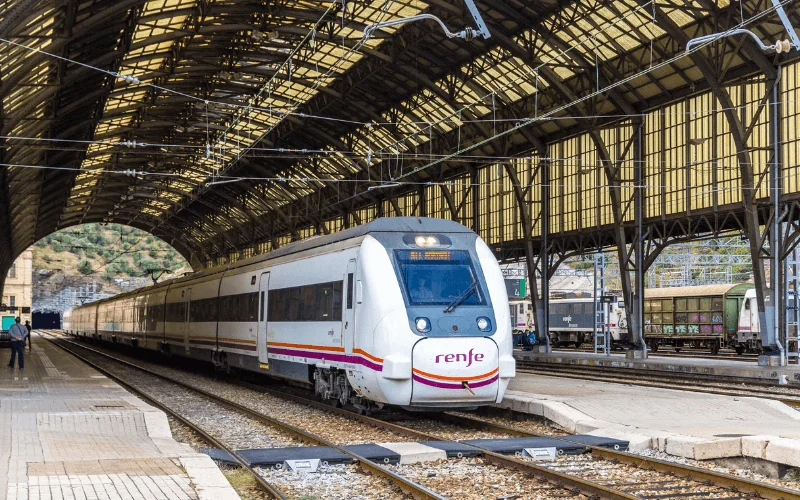 Renfe train at a Spanish railway station under a covered platform