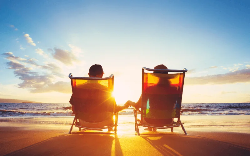 Retired couple enjoying sunset on a peaceful beach holiday