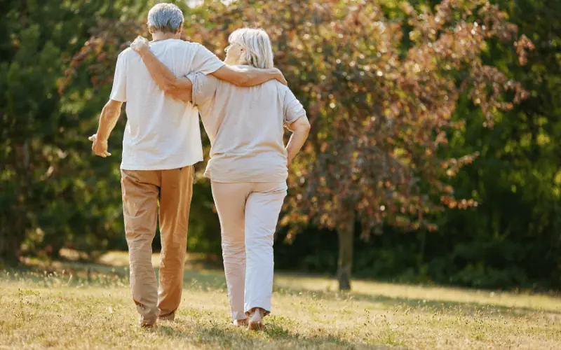 Retired couple walking in a sunny park enjoying peaceful life in Spain
