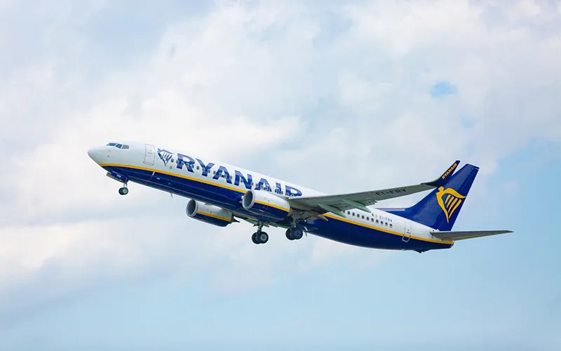 Ryanair plane taking off into a partly cloudy sky