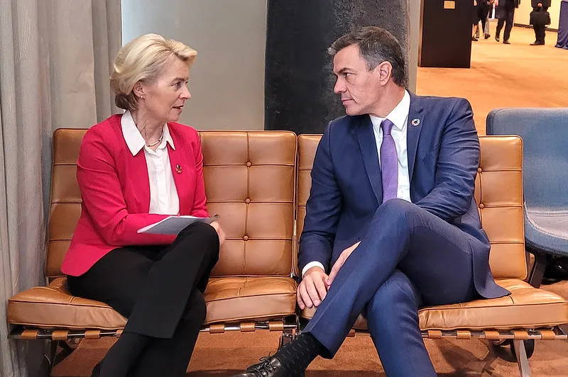 Two political leaders in conversation while seated at a formal event