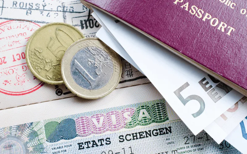 Schengen visa with euro coins and passport on travel documents
