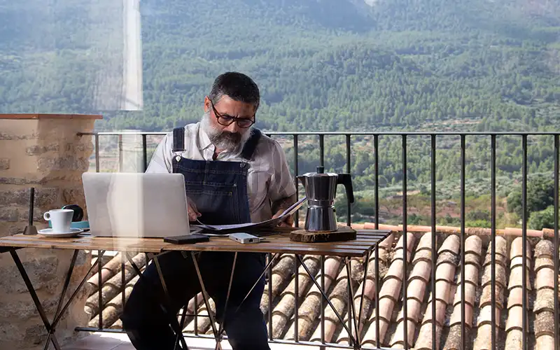 Remote worker sitting on a terrace in rural Spain