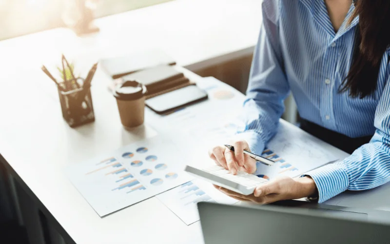 Self-employed professional reviewing financial data with calculator at desk