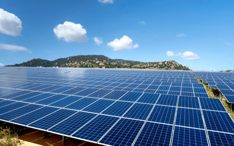 Large solar panel field in Spain with blue sky and hills in the background