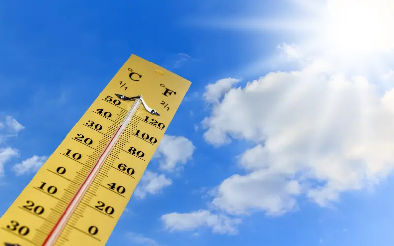 thermometer reaching high temps under clear bly sky