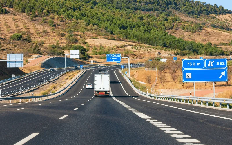 Highway road in Catalonia Spain with directional signs and surrounding hills