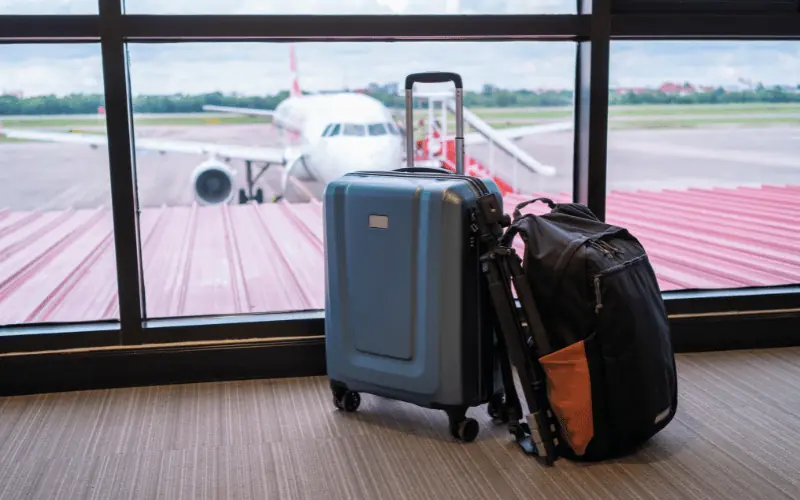 Luggage at airport gate with airplane ready for boarding