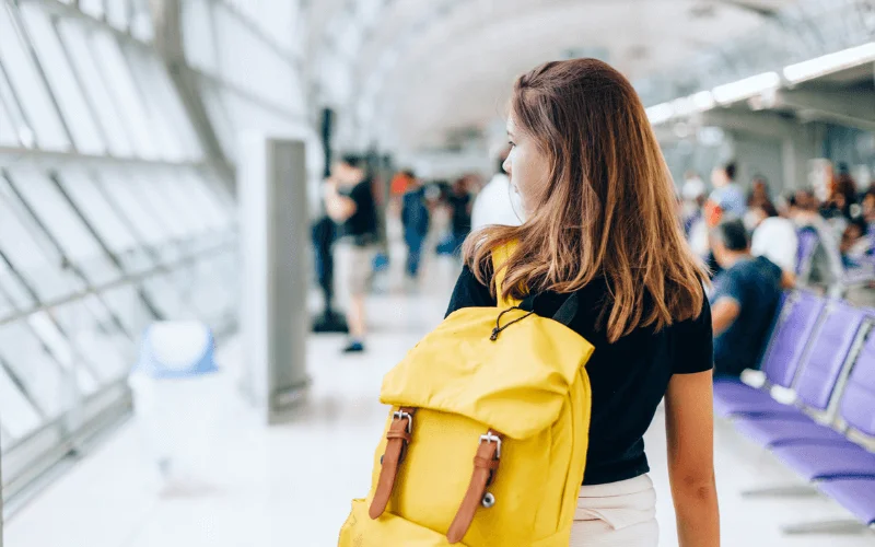 Teenager traveling through airport with backpack
