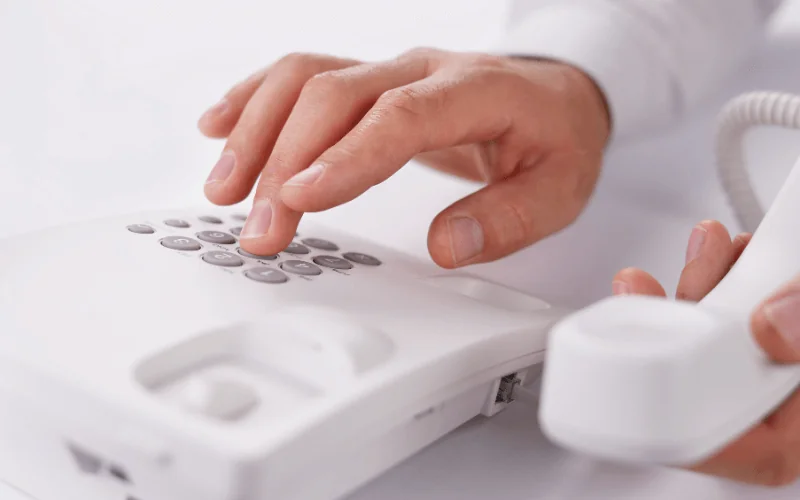 Close-up of person dialing a landline telephone during a business call