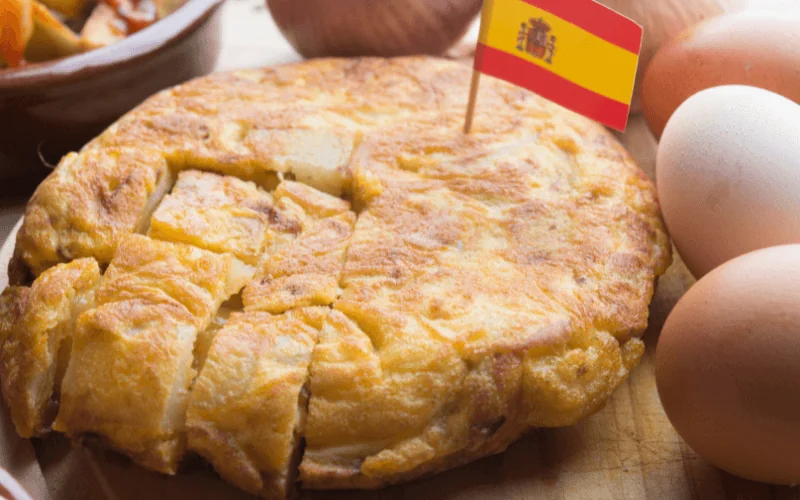 Traditional Spanish tortilla de patatas served with eggs and national flag