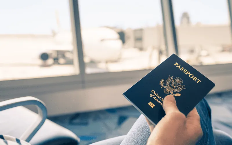 Traveler holding a U.S. passport while waiting at the airport gate
